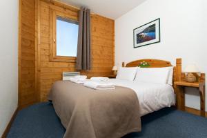 拉普拉涅节日夫人高山牧场小屋酒店的一间卧室配有一张大床和毛巾