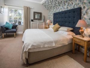 Saint Boswells巴克卢阿姆斯宾馆的一间卧室配有一张大床和蓝色床头板