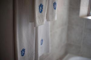 拉库布蕾Boutique Hotel Sevilla的浴室设有蓝图设计白色毛巾和浴帘