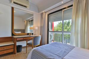 巴拉那巴拉那大酒店的一间卧室配有书桌、床和窗户。