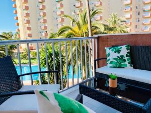 阿尔姆尼卡Apartamento Góndolas的一个带椅子的阳台和一个游泳池