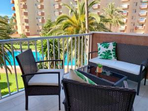 阿尔姆尼卡Apartamento Góndolas的阳台配有椅子和一张沙发的桌子