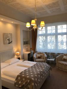 汉堡达姆托帕拉斯菲森纳酒店的一间卧室配有一张大床和两把椅子