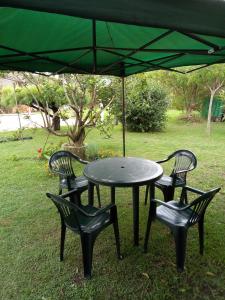 拉科罗尼亚La Coronilla ,Casa de Campo的绿伞下的一张桌子和两把椅子