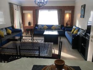 阿加迪尔Marina Apartment Agadir的客厅配有蓝色的沙发和桌子