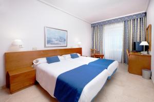 大加那利岛拉斯帕尔马斯和蔼酒店的一间卧室配有一张大床和电视