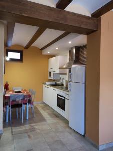 塞利亚Casa rural Abascal的厨房配有桌子和白色冰箱。