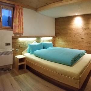 圣加伦基希Alpenchalet Garfrescha的一间卧室配有一张带蓝色枕头的大床