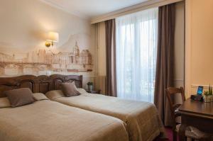 巴黎福美来酒店的酒店客房设有两张床和窗户。