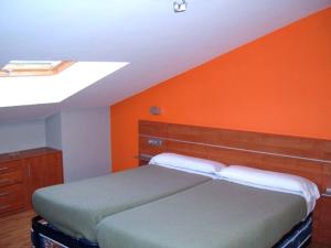 埃尔纳尼Pardiola Baserria的一间卧室配有一张橙色墙壁的床