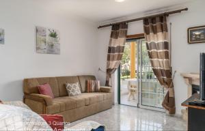 阿尔布费拉Akisol Albufeira Falesia IV的带沙发和滑动玻璃门的客厅