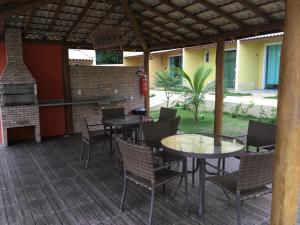 因巴塞Imbassai Summer Flats Village的一个带桌椅和烧烤设施的庭院