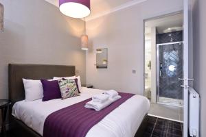 爱丁堡Destiny Scotland Charlotte Square Apartments的卧室配有一张大白色床和紫色床单