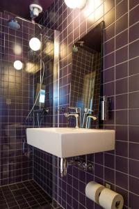索尔瓦根霍尔门罗弗敦旅馆的浴室设有水槽、镜子和紫色瓷砖