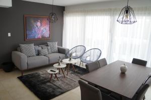 瓜达拉哈拉Metropolitan Suites的客厅配有沙发和桌子