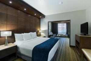 斯波坎Oxford Suites Spokane Downtown的酒店客房,配有床和电视