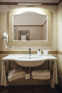 福贾La Magione的浴室内的盥洗盆,配有镜子和毛巾