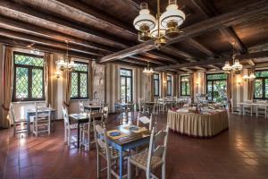 西尔米奥奈多加纳酒店的用餐室设有桌椅和窗户。