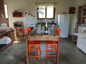 贡萨尔维斯Casa Vista da Lagoa的厨房配有带橙色椅子的桌子和冰箱