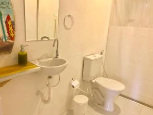 普拉亚多Pousada Mel的白色的浴室设有水槽和卫生间。