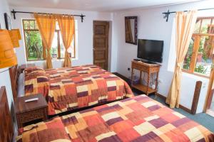 库斯科安妮塔旅馆的一间卧室配有两张床和一台平面电视