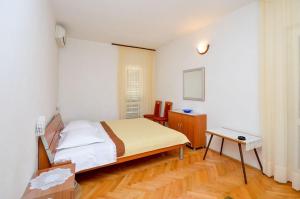诺瓦利娅Apartment and Rooms Biserka的一间小卧室,配有一张床和一张桌子