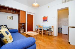诺瓦利娅Apartment and Rooms Biserka的客厅配有蓝色的沙发和桌子