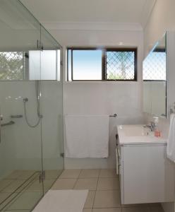 布里斯班Holiday House的带淋浴和盥洗盆的白色浴室