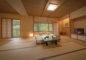 福岛Iizaka Onsen Surikamitei Ohtori的一个带桌椅的大客厅