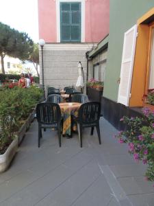 莫内利亚意大利酒店的一座带四把椅子和一张桌子的庭院以及一座建筑