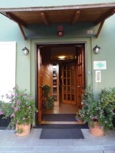 莫内利亚意大利酒店的两棵植物的房子的前门