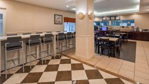 Massapequa Park酒吧港贝斯特韦斯特酒店的餐厅设有酒吧和桌椅