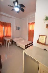 公主港Las Residencias Bed And Breakfast的客房设有两张床和吊扇。