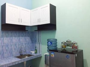 巴图Villa Aviation by Masterpiece Villa的厨房配有白色橱柜、水槽和冰箱。