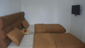 武吉丁宜Al Barra Syariah Hotel的房间里的一张沙发和一把椅子