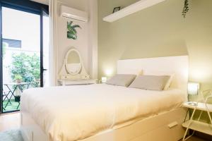 马拉加Family apartment Patio&Swimming pool in center Malaga的一间卧室设有一张大床和一个大窗户