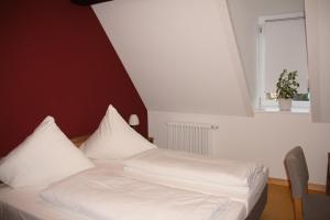 诺德海姆市场Wirtshaus am Markt的一间卧室配有一张带白色床单的床和一扇窗户。