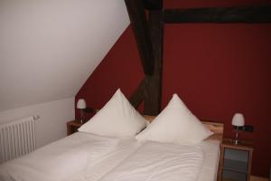 诺德海姆市场Wirtshaus am Markt的一间卧室配有带白色床单和枕头的床。