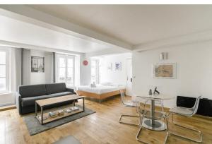 巴黎50m2 rue rambuteau/Pompidou/Marais/Hôtel de Ville的客厅配有沙发和1张床