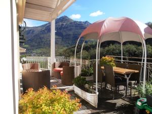 吕兹-圣索沃尔埃德拜斯全景酒店的庭院配有桌椅和遮阳伞。