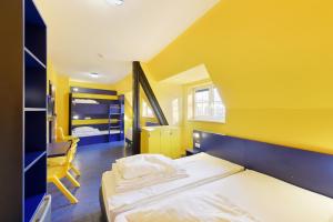 汉诺威廉价世博旅馆的黄色客房,配有床和椅子