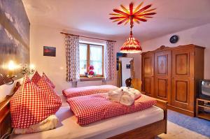 巴特欣德朗Landhaus Carolin Göhl的一间卧室配有两张带红白色枕头的床