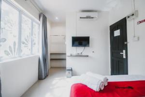 巴淡岛中心RedDoorz @ Baloi Batam的一间卧室配有红色的床和电视