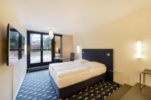 汉诺威威耶堡酒店的酒店客房设有一张床和一个大窗户