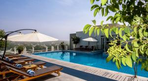 杜尚别杜尚别塞雷纳酒店的酒店游泳池设有椅子和遮阳伞