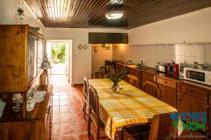 普拉亚达维多利亚Hospedaria casa D'Avo的厨房配有一张桌子,上面有黄色的桌布