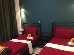 安曼诺贝尔酒店的配有红色床单和2张单人床的客房
