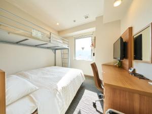 三原市Super Hotel Mihara Ekimae的一间卧室配有一张床和一张书桌及电视