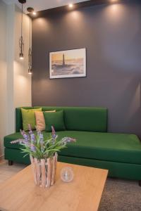 尼亚·蒙达尼亚索克拉提斯酒店的客厅配有一张绿色沙发,设有一张桌子