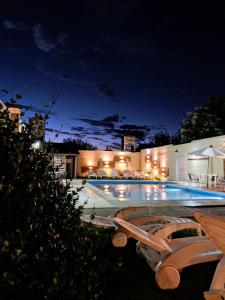 圣罗莎卡拉穆奇塔县Casablanca Hotel & Spa的游泳池在晚上设有两张躺椅